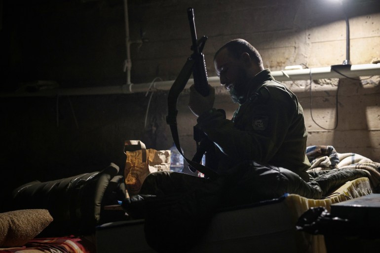 A Ukrainian serviceman checks his rifle in a bomb shelter in the frontline city of Bakhmut