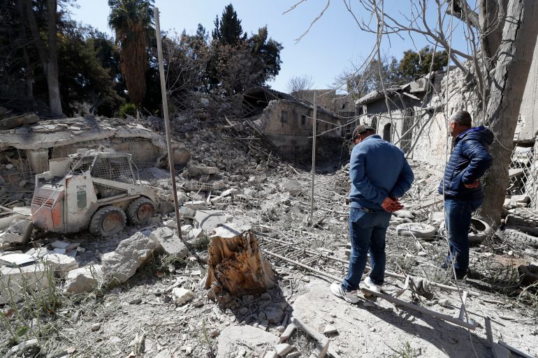 People inspect a blast zone in a residential area