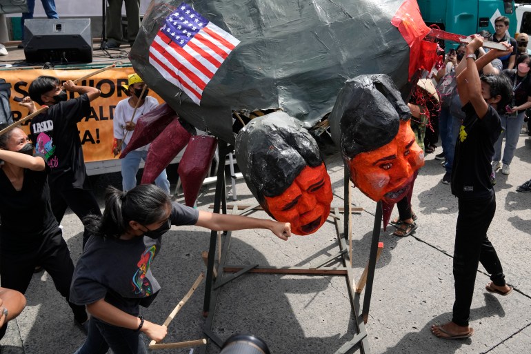 I manifestanti prendono a pugni un'effigie di Ferdinand Marcos Jr. È anche dipinta con una bandiera degli Stati Uniti.