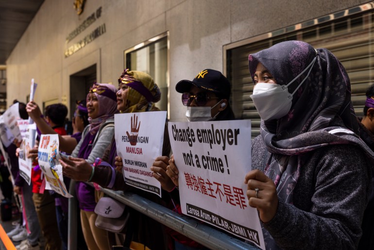 Pekerja rumah tangga memprotes untuk mendukung kondisi kerja yang lebih baik.  Mereka membawa plakat melawan apa yang disebut 'Aturan dua minggu'