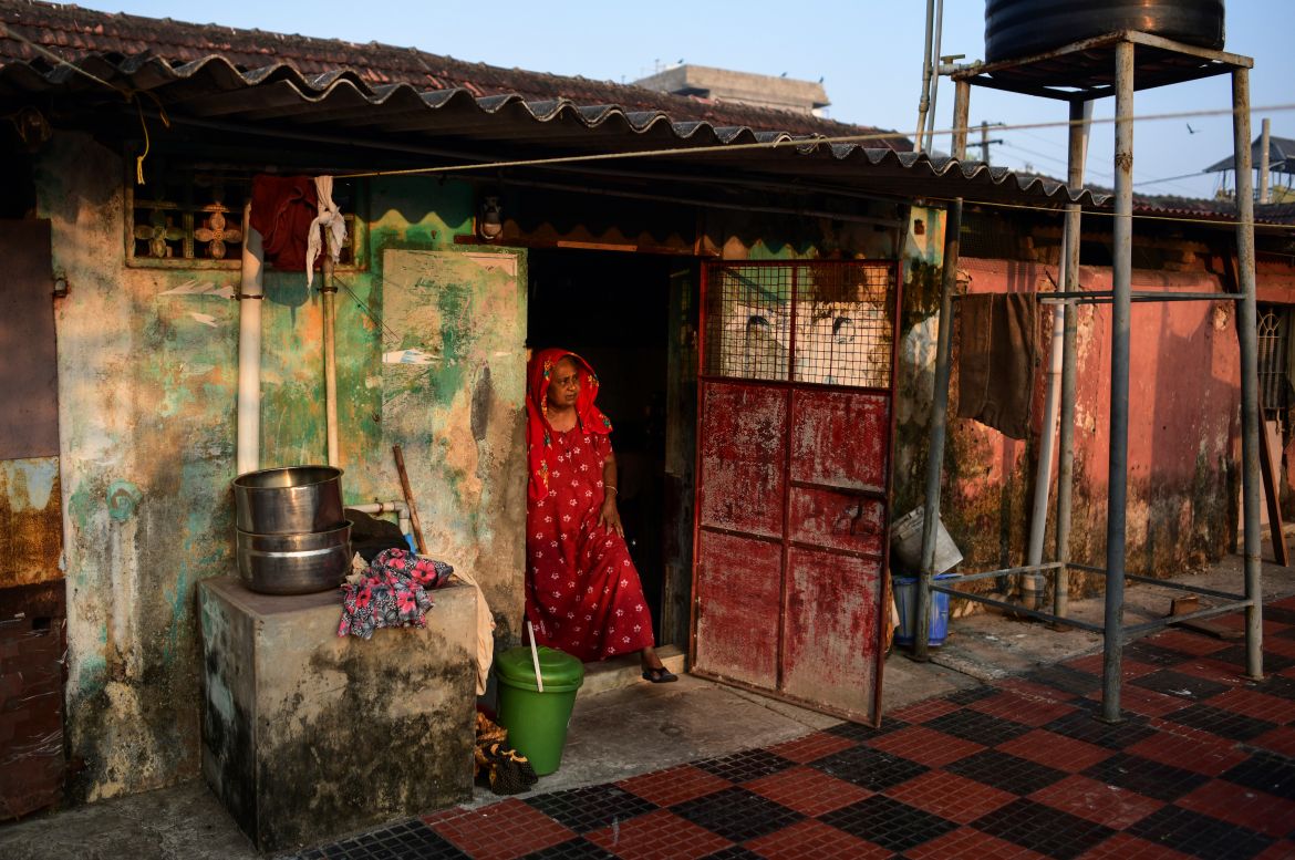65-year-old Zainaba Ali stands at the entrance of her daughter's asbestos-roofed house
