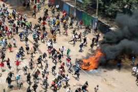 Protesters run towards riot police officers during a mass rally called by the Kenyan opposition