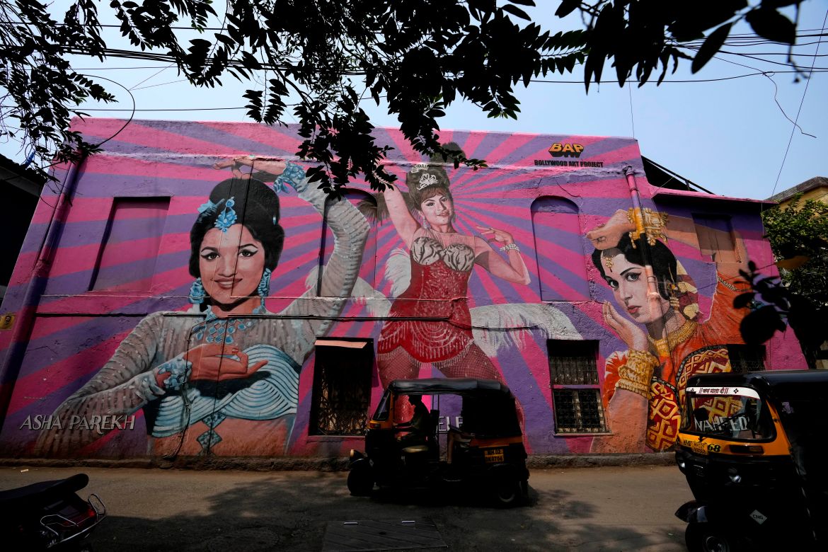 Autorickshaws drive past a mural of a Bollywood actress at Bandra in Mumbai,