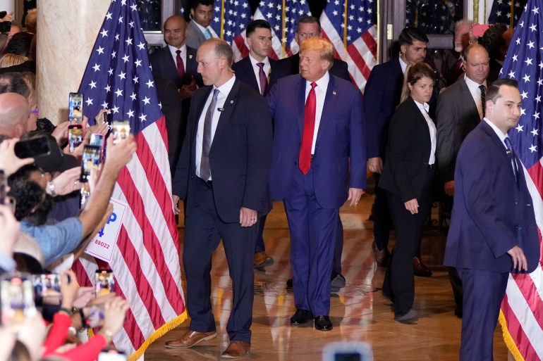 Trump walks out of ballroom, waves to crowd