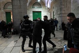 Israeli police detain a Palestinian worshipper at the Al-Aqsa Mosque compound