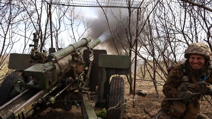 A Ukrainian soldier turning away after firing a howitzer at Russian positions near the frontline in Luhansk