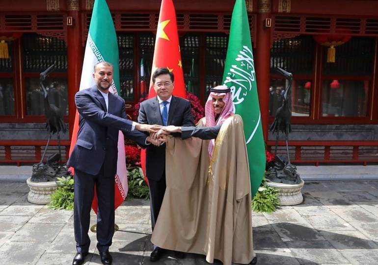 Iran's Foreign Minister Hossein Amirabudorahian, left, and Saudi Arabia's Foreign Minister Faisal bin Farhan Prince Al Saud, right, shakes hands with Chinese Foreign Minister Qin Gang in Beijing.  (Iran's Ministry of Foreign Affairs via Associated Press)