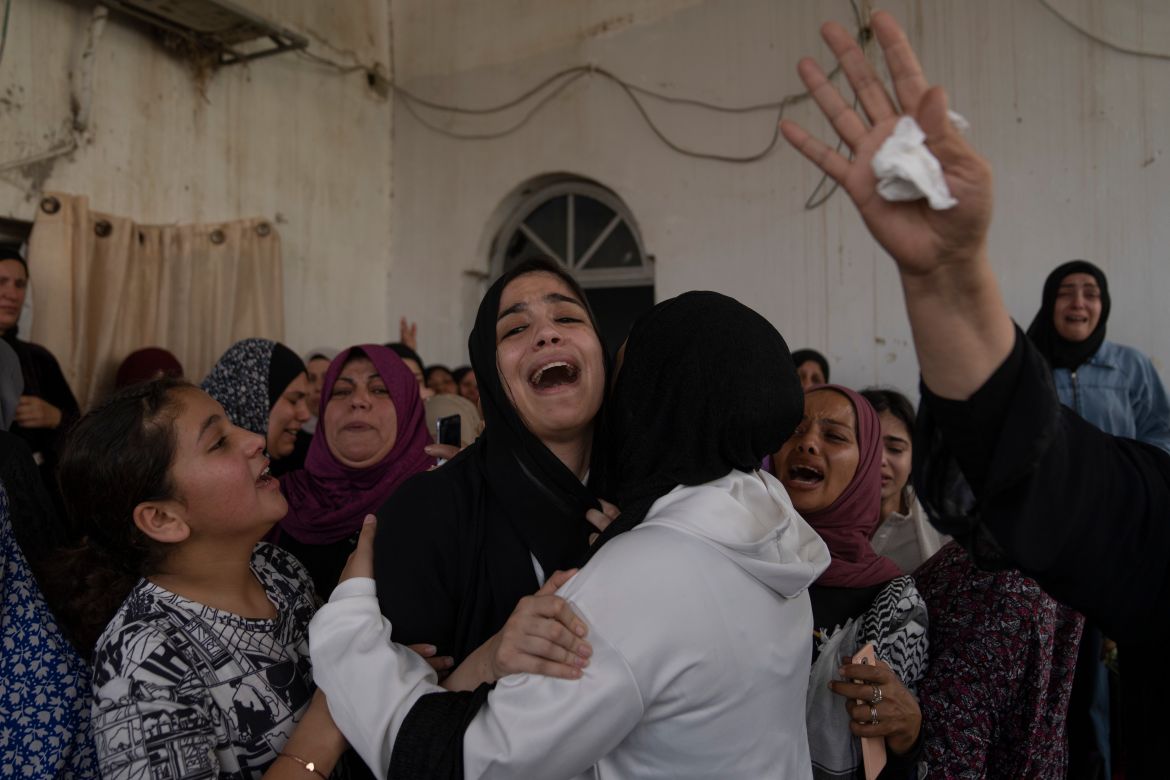 Palestinian mourners cry after taking the last look at the body of Mohammad Balhan