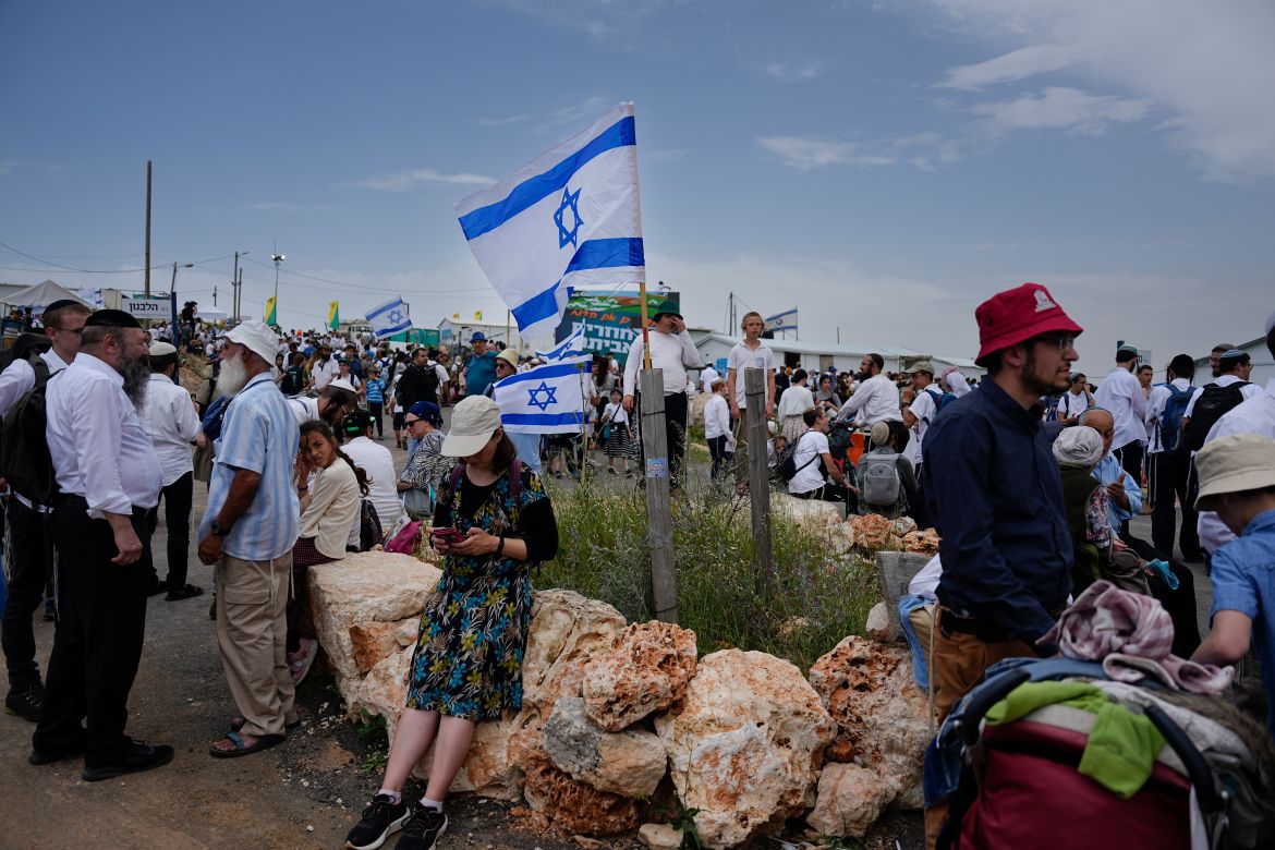 Israeli settlers walk around the outpost of Eviatar