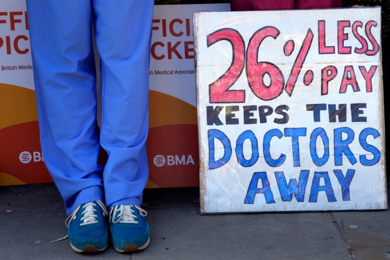 Dokter junior berdiri di barisan piket di luar Rumah Sakit St Thomas di Westminster, London.