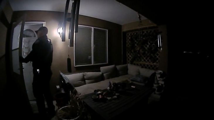 In this image taken from body camera video provided by the Farmington Police Department, a police officer knocks on the door of the wrong address in response to a domestic violence call