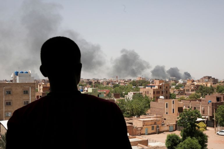 A person is silhouetted against the smoke-filled sky as they look towards Khartoum, Sudan, where fighting resumed after an internationally brokered cease-fire failed.