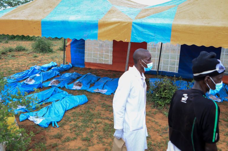 Some of the exhumed bodies of victims of a religious cult are laid out under blue tarpaulins in the village of Shakahola, near the coastal city of Malindi, in southern Kenya on April 23, 2023.