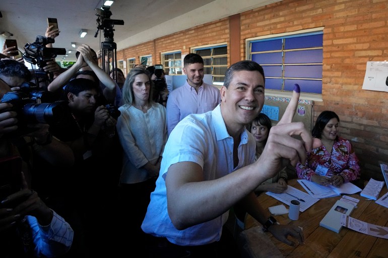 Santiago Pena, presidential candidate of the Colorado ruling party, shows his finger marked with ink after voting at a polling station during general elections in Asuncion, Sunday, April 30, 2023. (AP Photo/Jorge Saenz)