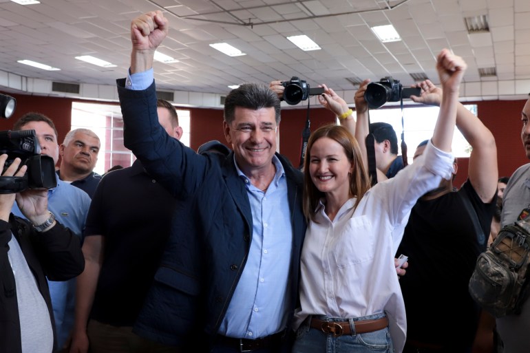 Efrain Alegre, presidential candidate for the Concertacion coalition, and running mate Soledad Nunez pose for a picture at a polling station during general elections in Lambare, outskirts Asuncion, Sunday, April 30, 2023. (AP Photo/Marta Escurra)