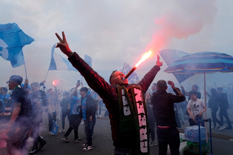 Napoli fans celebrates on the street after their team scored the first goal during the Serie A soccer match between Napoli and Salernitana at the Diego Armando Maradona stadium