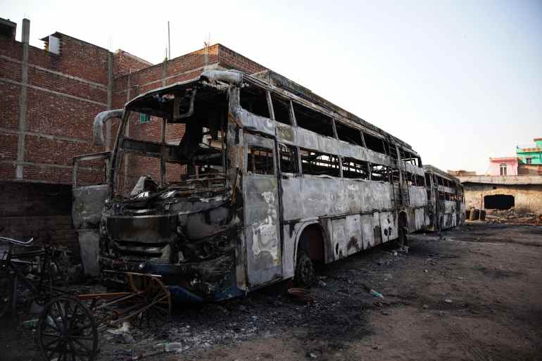 Remains of a burnt bus at the parking lot of Mohammad Murtaza. The rioters torched two mosques, a seminary, shops and vehicles.