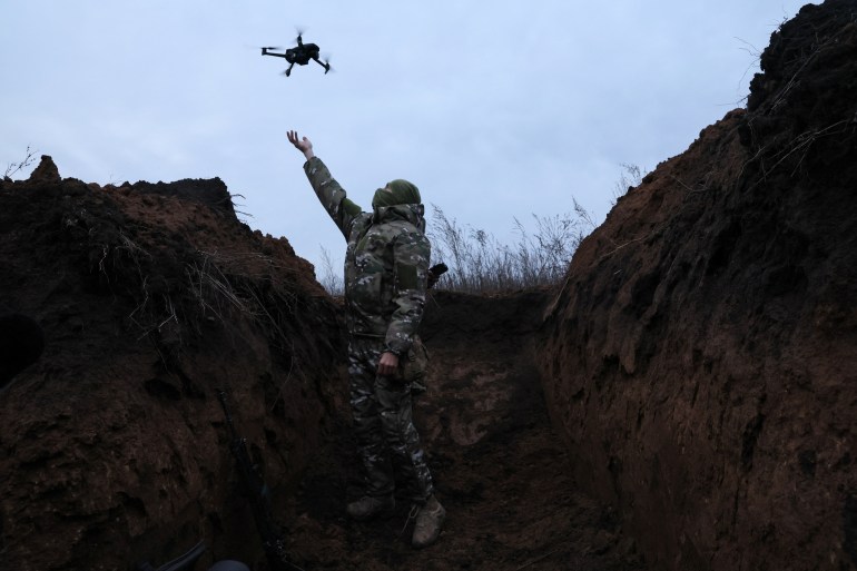 A photo of a soldier letting go of a small drone.