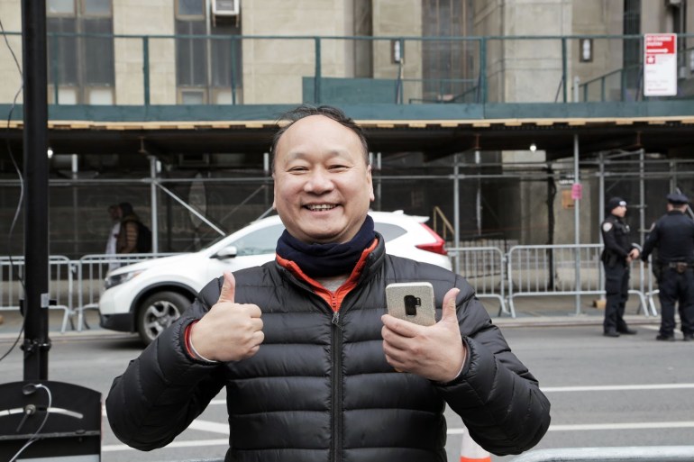 Maxwell Lau, seorang pemilik bisnis Chinatown berusia 62 tahun bersorak ketika melihat kerumunan turis, petugas polisi dan wartawan berkumpul di luar pengadilan beberapa jam sebelum penampilan pengadilan Trump.  (Dorian Geiger/Al Jazeera)