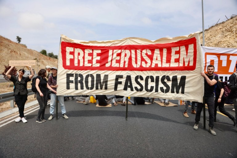 People on street holding banner that says 'Free Jerusalem From Fascism'