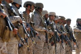 Saudi soldiers stand in line at an airfield where Saudi military cargo planes land to deliver aid in Marib
