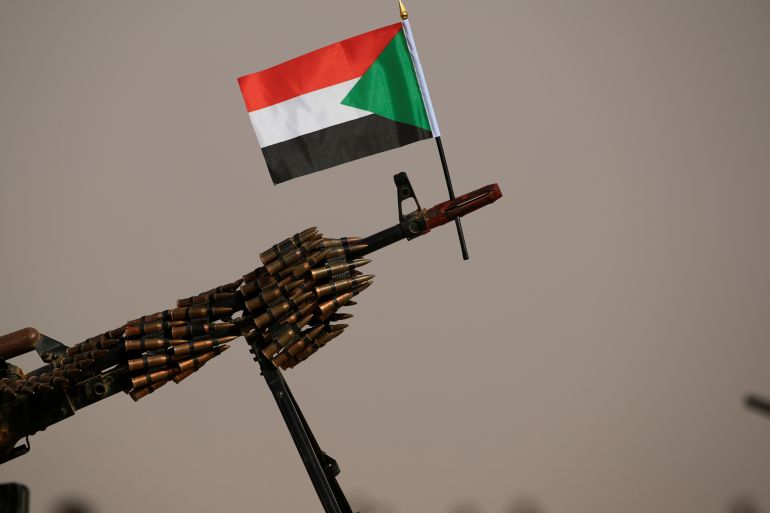 A Sudanese national flag is attached to a machine gun of RSF soldiers