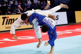 Azerbaijan's Mammadali Mehdiyev and Russia's Khusen Khalmurzaev fly through the air as they compete in the Tokyo judo world championships
