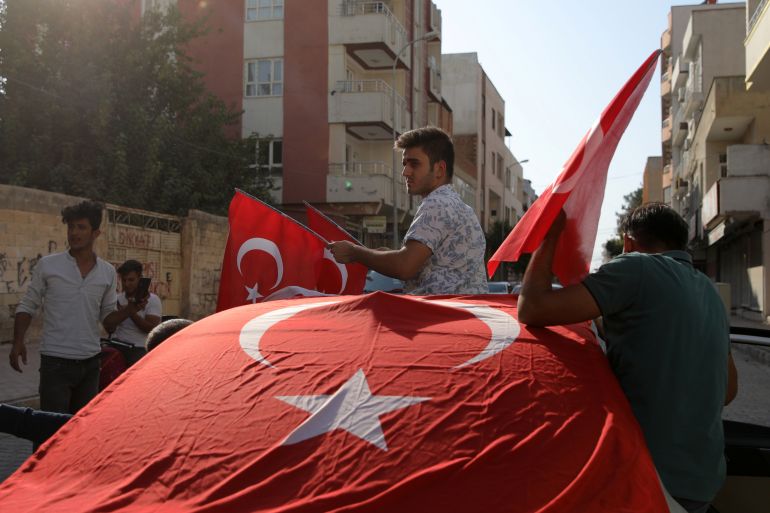 터키 민족주의자들이 터키 국경 도시 악카칼레의 거리에서 환호하고 있습니다.
