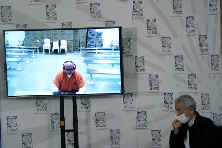 Former paramilitary leader Salvatore Mancuso gives testimony though live video screen to the country's truth commission as Francisco de Roux, President of the Truth Commission, looks on