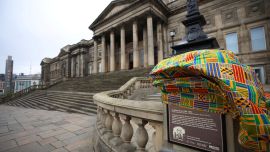 Traditional African Kente Cloth covers a newly installed plaque, explaining the links to the street name and the slave trade is seen outside the World Museum in Liverpool, Britain, April 5, 2022.