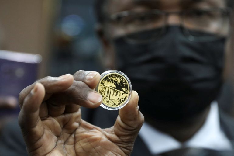 Reserve Bank of Zimbabwe (RBZ) Governor John Mangudya poses for a photograph with a sample of a gold coin during its launch in Harare, Zimbabwe, July 25, 2022 [Philimon Bulawayo/Reuters]