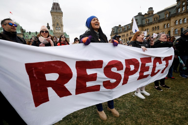 Striking federal workers hold a banner reading 'Respect' on Parliament Hill in Ottawa