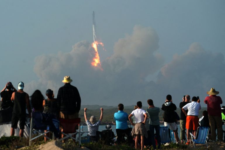 SpaceX's next-generation Starship spacecraft atop its powerful Super Heavy rocket lifts off from the company's Boca Chica launchpad on a brief uncrewed test flight near Brownsville, Texas, the US. Dozens of people can be seen in the foreground watching the lift off.