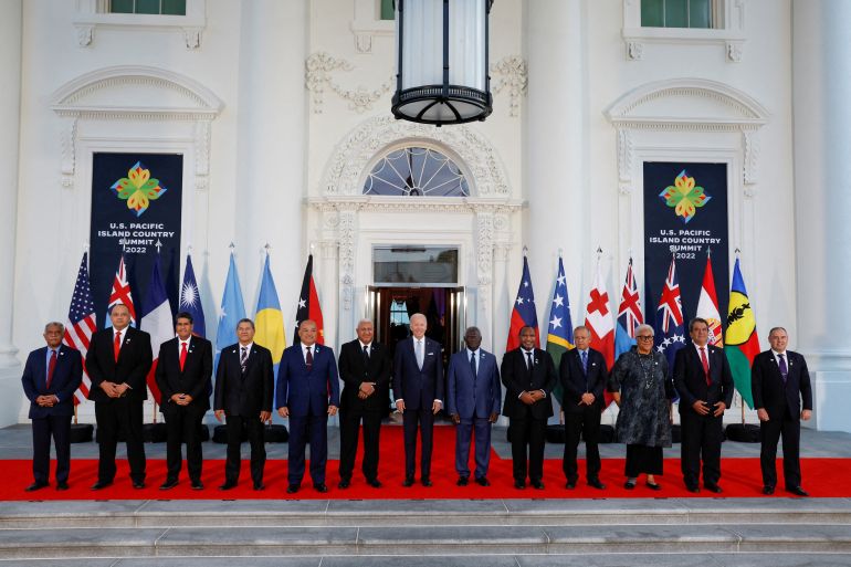 US President Joe Biden with Pacific leaders outside the White House. The flags of each country are hanging from poles behind the group