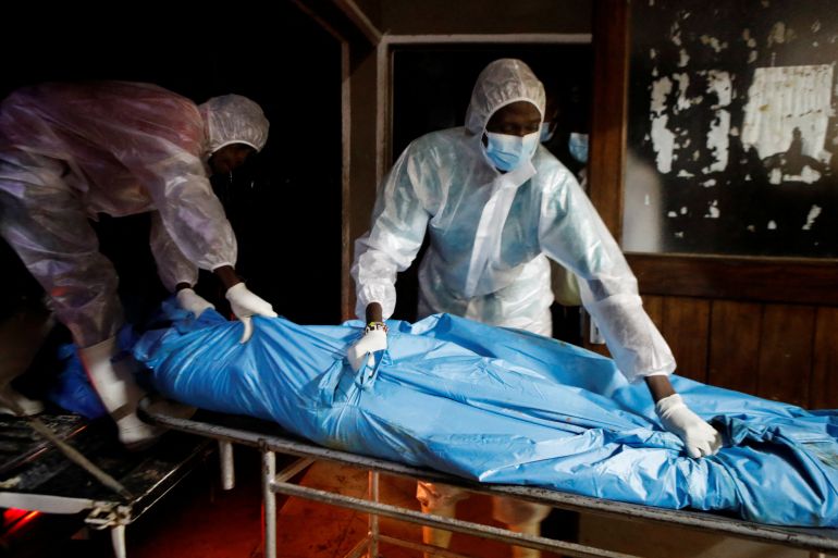 Workers receive the exhumed bodies of followers of a Christian cult named Good News International Church