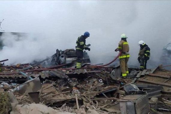Firefighters work at blast site