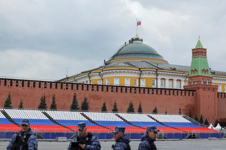 Russian law enforcement officers stand guard in Red Square, with people seen on the dome of the Kremlin Senate building in the background, in central Moscow, Russia, May 3, 2023.