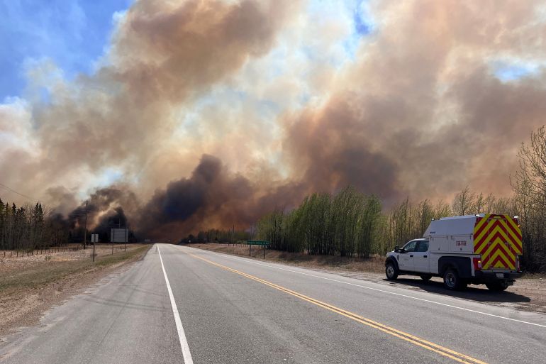 A smoke column rises due to wildfires in Alberta, Canada