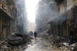People inspect damage at a site hit by what activists said were barrel bombs dropped by forces loyal to Syria's President Bashar al-Assad in Aleppo's district of al-Sukari