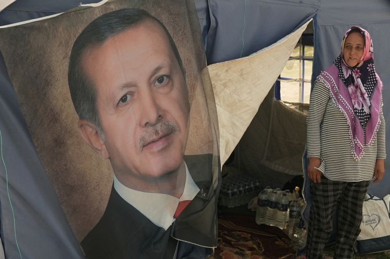Ayse Kekec, an earthquake survivor living in a tent with her son, stands in front of their tent with a poster of Turkish President Erdogan on it, in Kahramanmaras, Turkey May 11, 2023. REUTERS/Issam Abdallah TPX IMAGES OF THE DAY