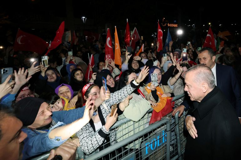 Turkish President Tayyip Erdogan greets his supporters as he leaves his residence in Istanbul