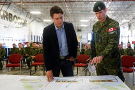 Canadian Prime Minister Justin Trudeau is briefed about wildfires in Alberta by a member of the Canadian Armed Forces in Edmonton.
