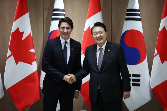 Canada’s Prime Minister Justin Trudeau shakes hands with South Korea’s President Yoon Suk Yeol