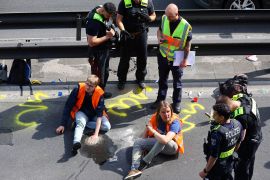 Police surround activists of the "Letzte Generation" (Last Generation) after they glued their hands on asphalt, while blocking the central highway A100 to protest for climate councils, a speed limit on highways as well as for affordable public transport, in Berlin, Germany, May 22, 2023.