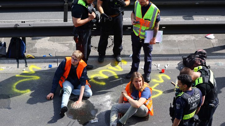 Police surround activists of the "Letzte Generation" (Last Generation) after they glued their hands on asphalt, while blocking the central highway A100 to protest for climate councils, a speed limit on highways as well as for affordable public transport, in Berlin, Germany, May 22, 2023.