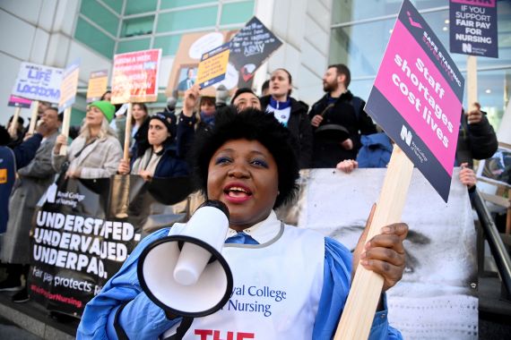 A person uses a megaphone as nurses protest during a strike by NHS medical workers amid a dispute with the government over pay, outside University College London Hospital in London, UK