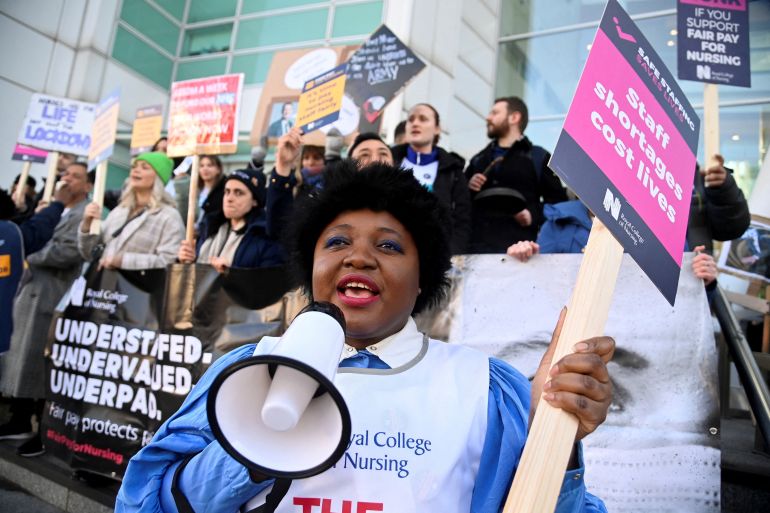 A person uses a megaphone as nurses protest during a strike by NHS medical workers amid a dispute with the government over pay, outside University College London Hospital in London, UK