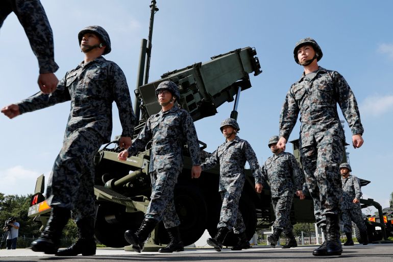 Japanese troops walking past a Patriot Advanced Capability-3 (PAC-3) missile unit