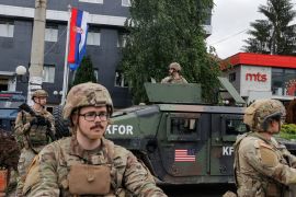 U.S. KFOR soldiers stand guard in front of the municipality office, while ethnic Serbs gather to protest, in the town of Leposavic, Kosovo, May 29, 2023.