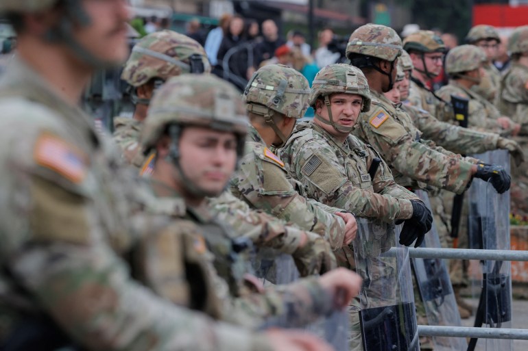 US KFOR soldiers stand guard in front of the municipality office, while ethnic Serbs gather to protest, in the town of Leposavic, Kosovo, May 29, 2023.
